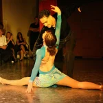 Couple dancing passionately on stage.